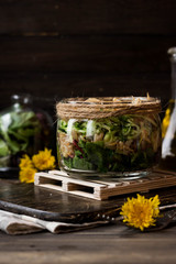 Fototapeta na wymiar Salad from sprouts of sprouted soy and dandelion leaves in a jar