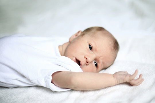 cute newborn baby lying on white blanket