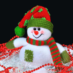 Toy decorated with a snowman, in the black background