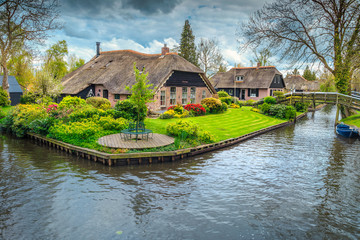 Fototapeta na wymiar Dutch village with colorful ornamental garden and spring flowers, Giethoorn