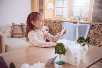 Modern entertainment. Positive happy girl holding a smartphone while watching a video