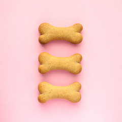 Set of bone-shaped biscuits for dog on pink background, concept pet care