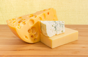 Pieces of various cheese on the bamboo wooden surface