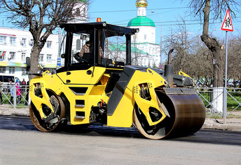 asphalt paver works in the city in the middle of the street