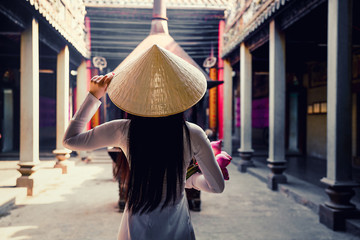 Vietnam woman wearing Ao Dai culture traditional at old temple at Ho Chi Minh in Vietnam,vintage style,travel and relaxing concept.