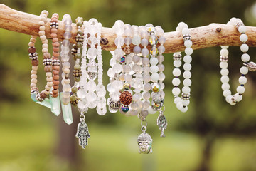 Natural bead bracelets hanging on natural branch - obrazy, fototapety, plakaty