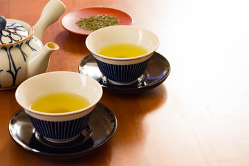 日本茶の茶葉とお茶と湯のみと急須