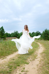 Fototapeta na wymiar young pretty bride in white wedding dress spin around