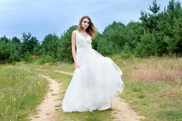 young pretty bride in white wedding dress outdoors, make up and hairstyle