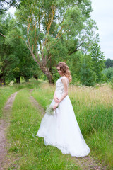 Obraz na płótnie Canvas young pretty bride in white wedding dress outdoors, make up and hairstyle