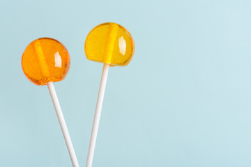 Lollipops on white sticks on blue pastel background with copy space