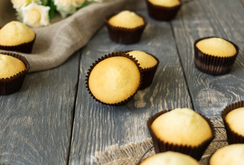 Baking - ready cupcakes in molds, on wooden surface