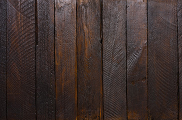 Dark rough stained wooden planks texture background