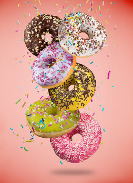 Tasty doughnuts in motion falling on pastel blue background.