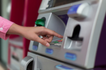 Close up of female hand entering PIN pass code on ATM bank machine keypad