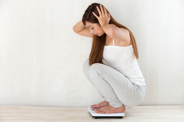 Fototapeta na wymiar 体重をはかる女性 