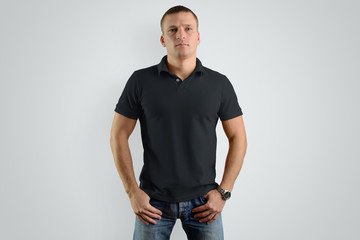 Mockup black  polo shirts.  Athletic man is isolated on a gray background. © olegphotor