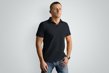 Front mockup black  polo shirt on a  muscular man isolated on a gray background.