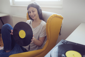 Young audiophile enjoy music on turntable and holding music record