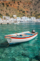 Fishing boat and the scenic village of Loutro in Crete, Greece