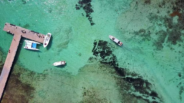 Aerial drone shot. View from above of the boat with divers and the pier in the distance from a bird's eye view. Turquoise water view coral coast of the Caribbean Sea. Riviera Maya Mexico.