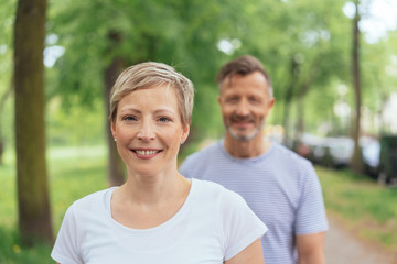 Obraz premium Cheerful mature woman with man in background