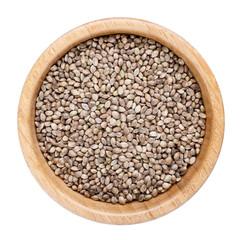 Hemp seeds in wooden bowl isolated on white. Top view.