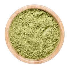 Powdered matcha green tea in wooden bowl isolated on white. Top view.