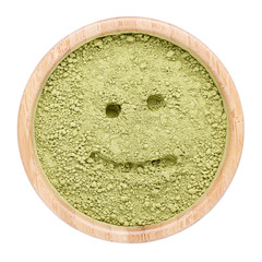 Powdered matcha green tea in wooden bowl isolated on white. Top view.