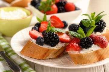 Healthy breakfast fruits and ricotta sandwiches- with strawberries, blueberries and blackberries.