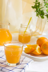 Orange juice with a glass cup and fresh fruit on a table breakfast in a summer afternoon in rustic style