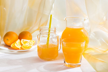Orange juice with a glass cup and fresh fruit on a table breakfast in a summer afternoon in rustic style