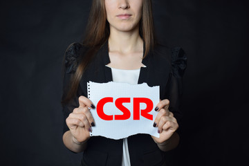 In the hands of a businessman a scrap of paper with the inscription:CSR