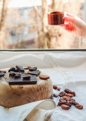 Chocolate and a cup of coffee in woman hand. Good morning concept.