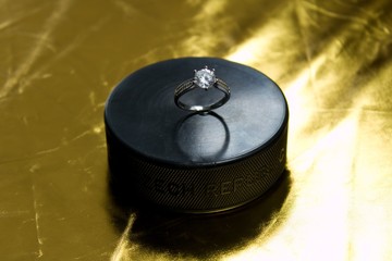 Engagement Ring on hockey puck with the inscription `Czech Republic` on the golden background.Black...