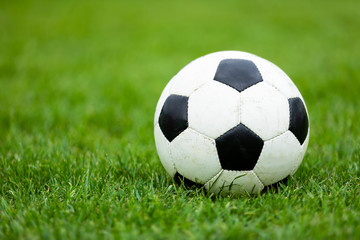 Fototapeta na wymiar Classic Soccer Football Ball on Soccer Pitch. Green Grass Soccer Field. Soccer Turf in the Background