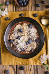Smoothie bowl on white plate on wooden table