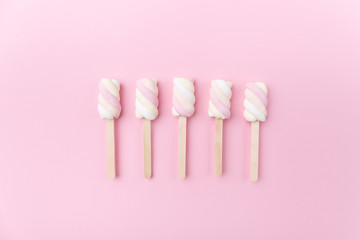 Marshmallows on sticks on tender pink background