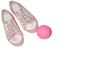 Composition of children's things: sneakers and ball on an isolated white background. The concept of vacation and summer holidays