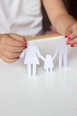 Little girl holds paper chain family; happy  or broken family concept