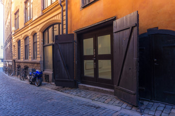 Motorcycle and wooden gate on the Old Town street in Stockholm,