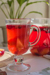 Delicious cranberry drink in a glass on a rustic background in a rural house closeup
