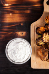 Grilled chicken meat next to grilled vegetables on a wooden board