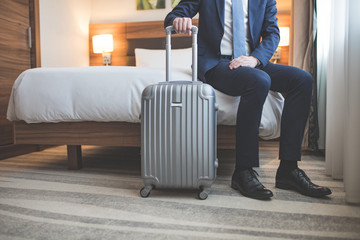 Young businessman with a suitcase in room