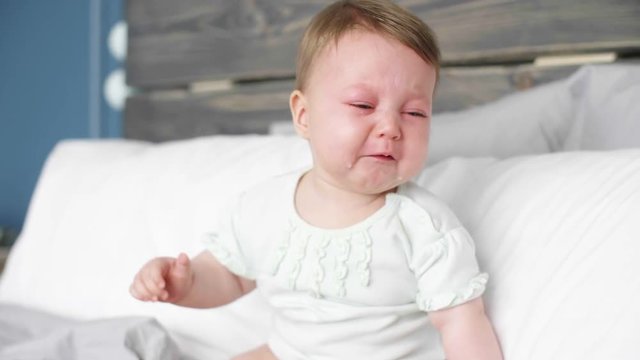 Tired baby crying at bedroom