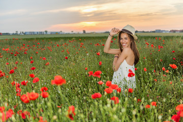 Obraz na płótnie Canvas Happy woman in the field of red poppies