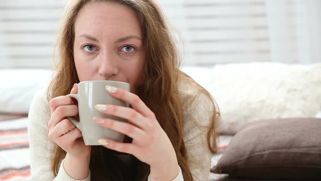 woman drinks coffee in bed bedroom