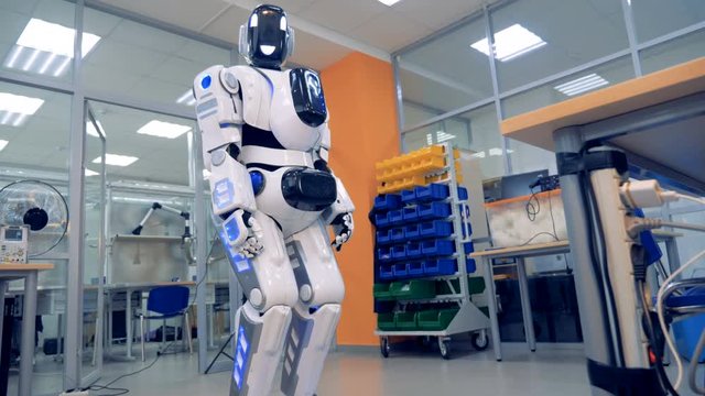 Human-like robot is rotating its head and looking into the camera
