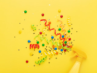 Party spray concept on yellow background.
