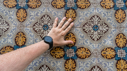 Hand touching traditional ceramic patterns tiles from Lisbon, Portugal